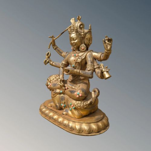 fig 1. A gilt bronze multi-armed deity figure seated atop a lion mount with turquoise and coral bead ornamentation.