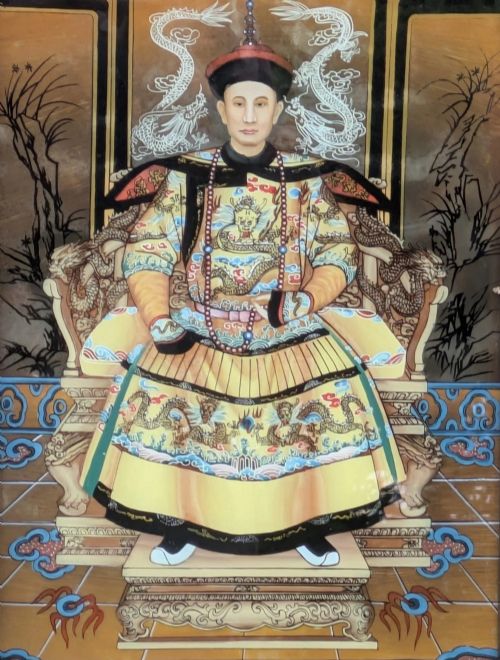fig 1. Reverse glass painting depicting a seated Chinese dignitary on a dragon throne in ceremonial robes, encased in a dark hardwood frame with a brass hanger.