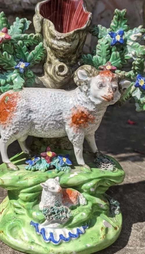 fig 1. An antique Staffordshire pearlware spillholder depicting a standing ram and seated lamb set against a tree trunk with green leaf bocage.