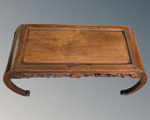 fig 1. A low Chinese rosewood table with curved legs, scroll feet, an inset timber top panel, and an intricately carved apron featuring traditional motif work.