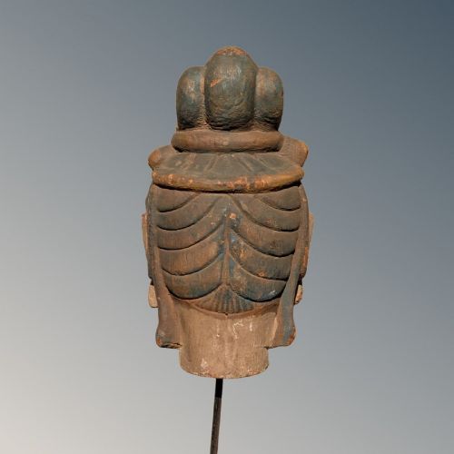 A carved wooden head of a Buddhist deity featuring an ornate tall crown, serene facial features, and residual surface pigments. View IV