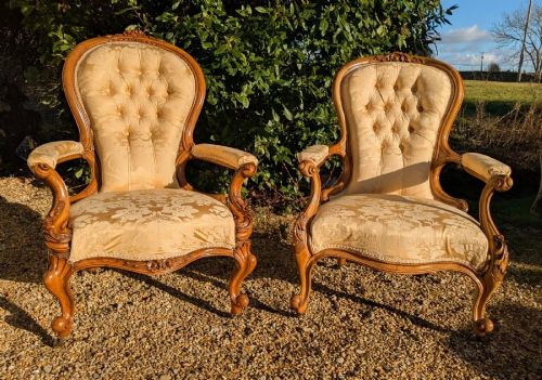 A matching pair of Victorian walnut spoonback armchairs with gold button-tufted upholstery and carved cabriole legs. View II