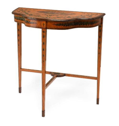 fig 1. A Regency satinwood side table with a shaped top decorated with hand-painted floral swags and a central cherub medallion, supported by slim tapering legs.