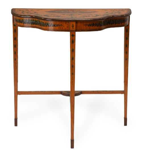 fig 2. A Regency satinwood side table with a shaped top decorated with hand-painted floral swags and a central cherub medallion, supported by slim tapering legs.