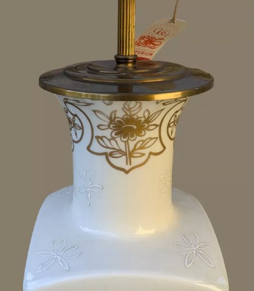 fig 2. A white square-form Paris porcelain table lamp with gilded floral motifs and a metal base, topped with a pleated fabric shade.