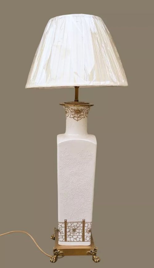 fig 1. A white square-form Paris porcelain table lamp with gilded floral motifs and a metal base, topped with a pleated fabric shade.