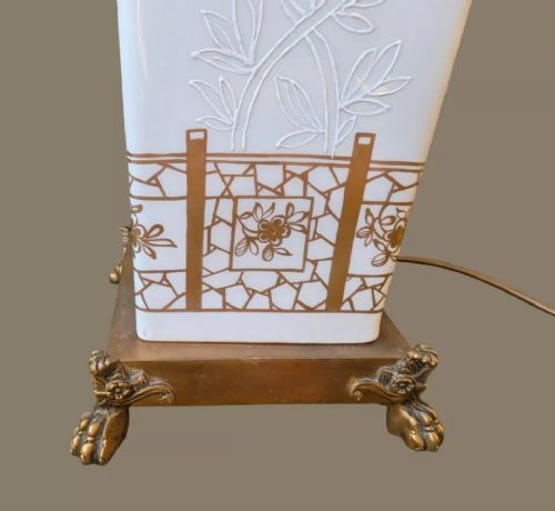 fig 3. A white square-form Paris porcelain table lamp with gilded floral motifs and a metal base, topped with a pleated fabric shade.