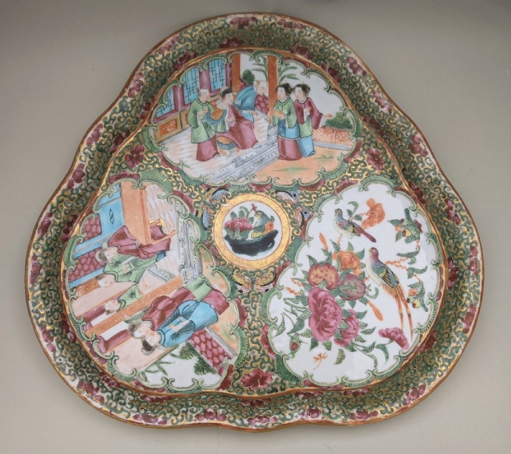 A trefoil-shaped Chinese porcelain dish featuring hand-painted panels of figures, birds, and floral motifs surrounded by a gilded green ground.