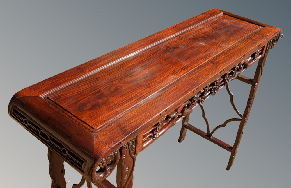 A carved Chinese rosewood altar table with raised everted flanges, pierced openwork apron, and carved legs. View IV