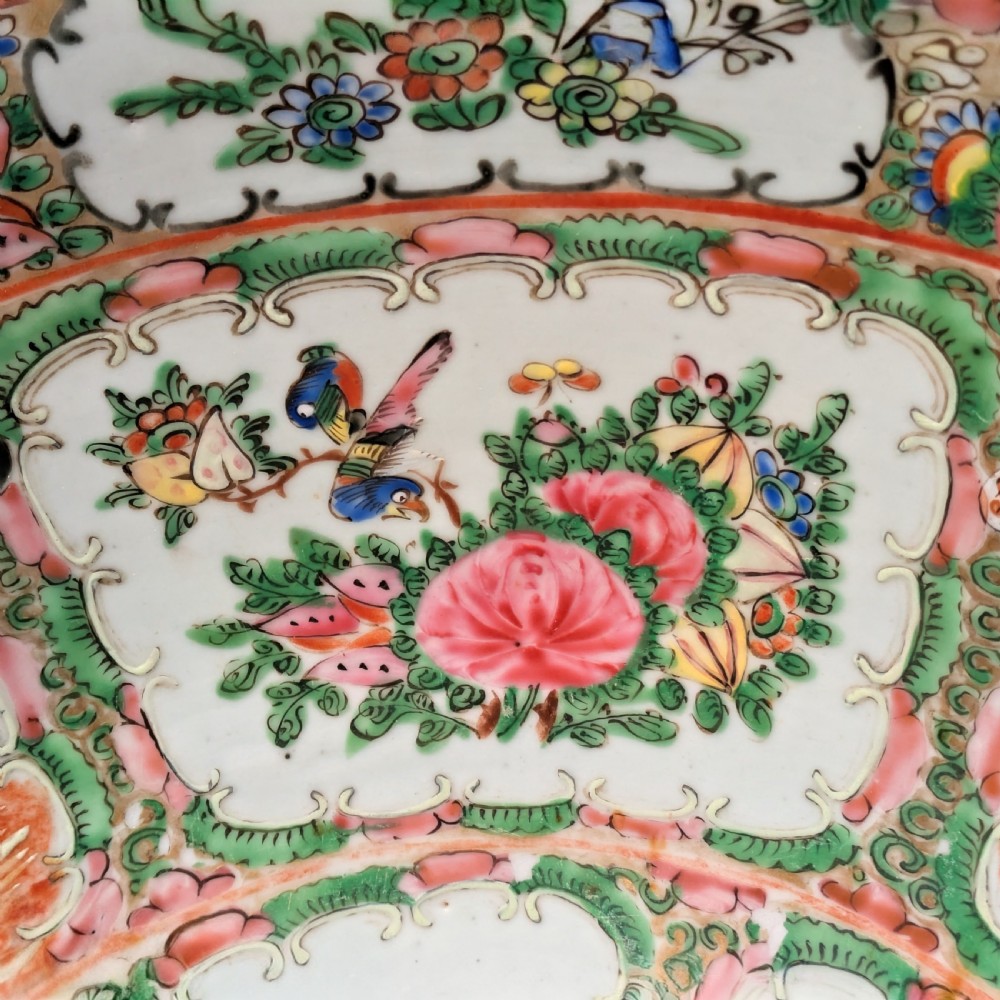 A top-down view of a circular 19th-century Chinese porcelain bowl featuring hand-painted Famille Rose enamels with alternating panels of figures and floral motifs. View VI