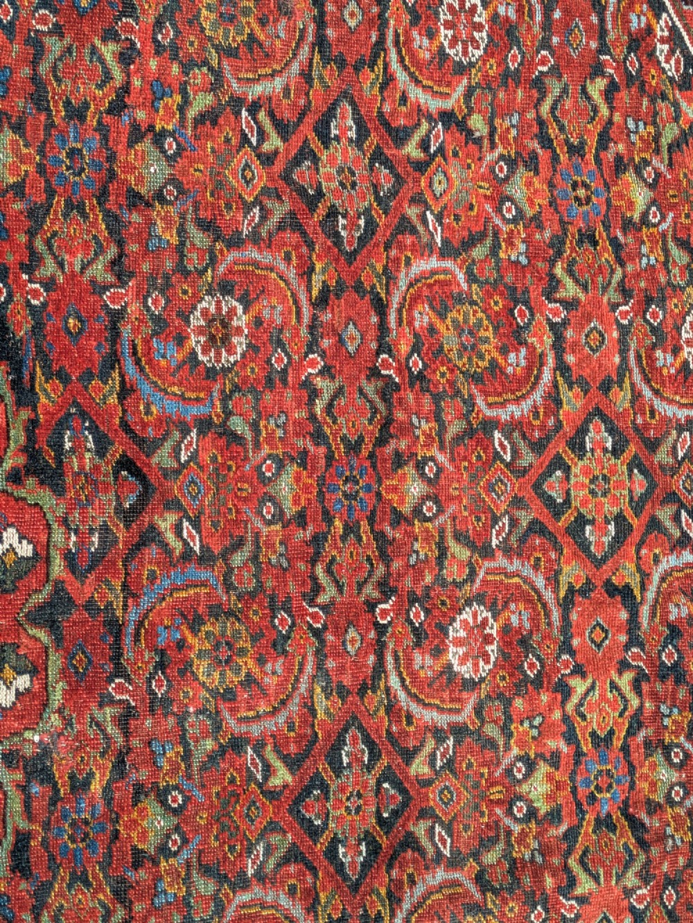 A rectangular hand-knotted Persian Khamseh carpet featuring three central floral medallions on a dense red patterned field with decorative borders. View II