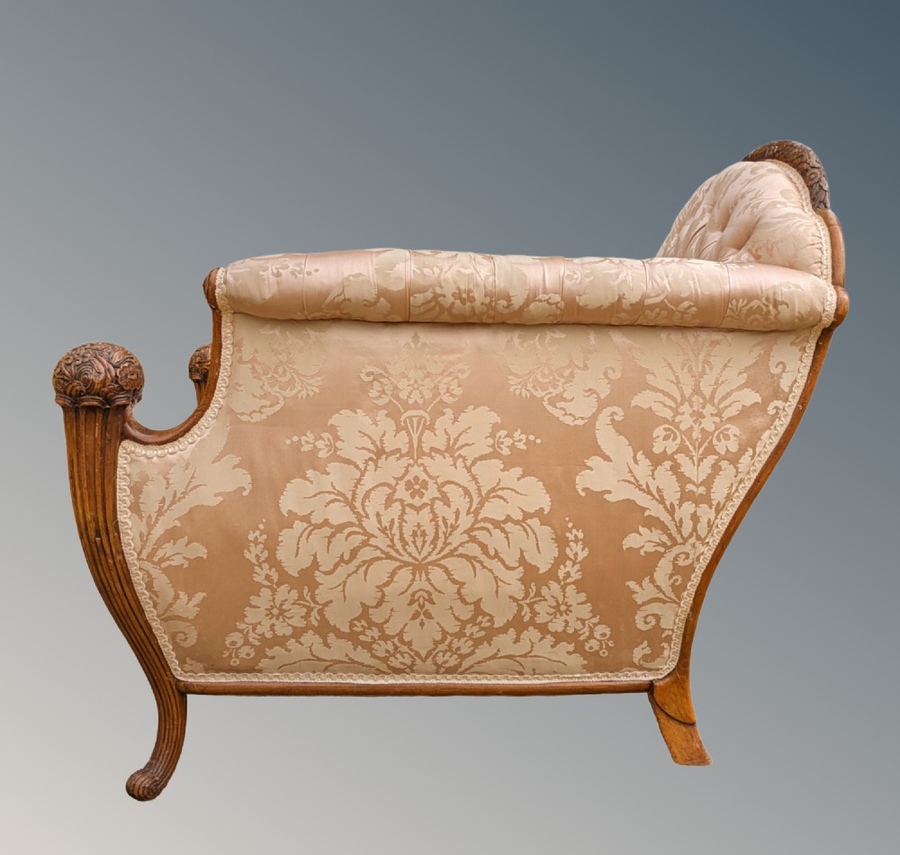 An antique French armchair featuring a carved walnut frame, button-tufted back, and champagne silk damask upholstery. View IV