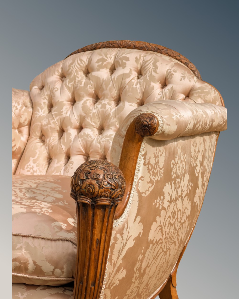 An antique French armchair featuring a carved walnut frame, button-tufted back, and champagne silk damask upholstery. View V