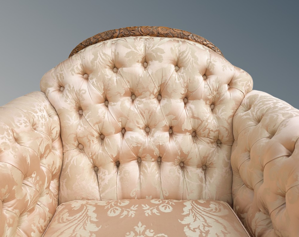 An antique French armchair featuring a carved walnut frame, button-tufted back, and champagne silk damask upholstery. View VI