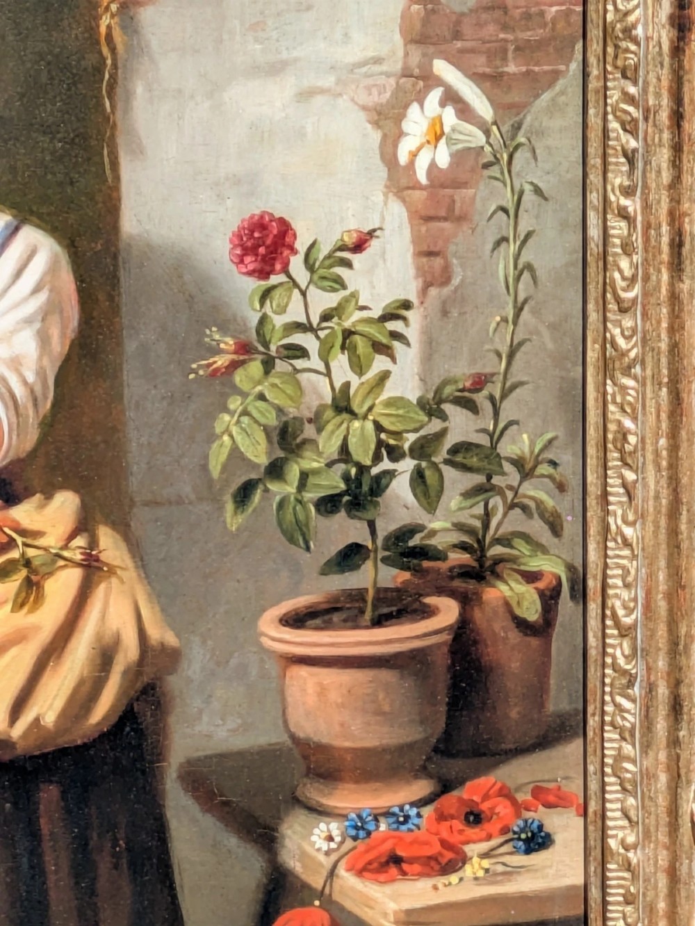 A 19th-century oil painting depicting a barefoot young woman standing outdoors in front of a cottage wall beside potted flowers, set within a deeply carved gilt frame. View III