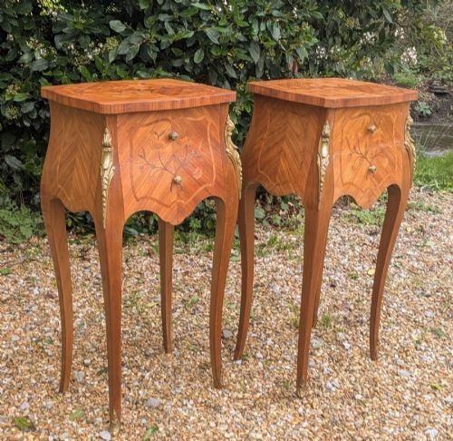 A pair of French Kingwood bedside cabinets featuring floral marquetry inlays, curved cabriole legs, and polished brass mounts.