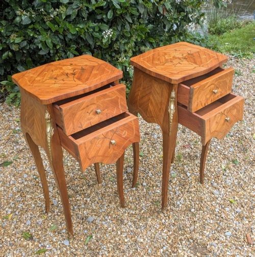 A pair of French Kingwood bedside cabinets featuring floral marquetry inlays, curved cabriole legs, and polished brass mounts. View VI