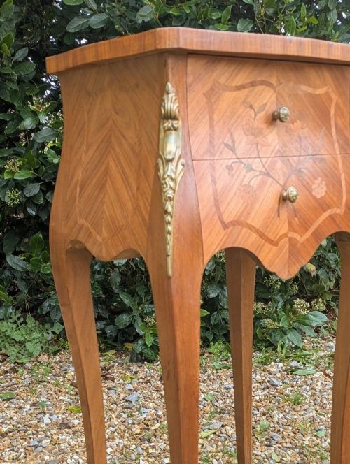 A pair of French Kingwood bedside cabinets featuring floral marquetry inlays, curved cabriole legs, and polished brass mounts. View VIII
