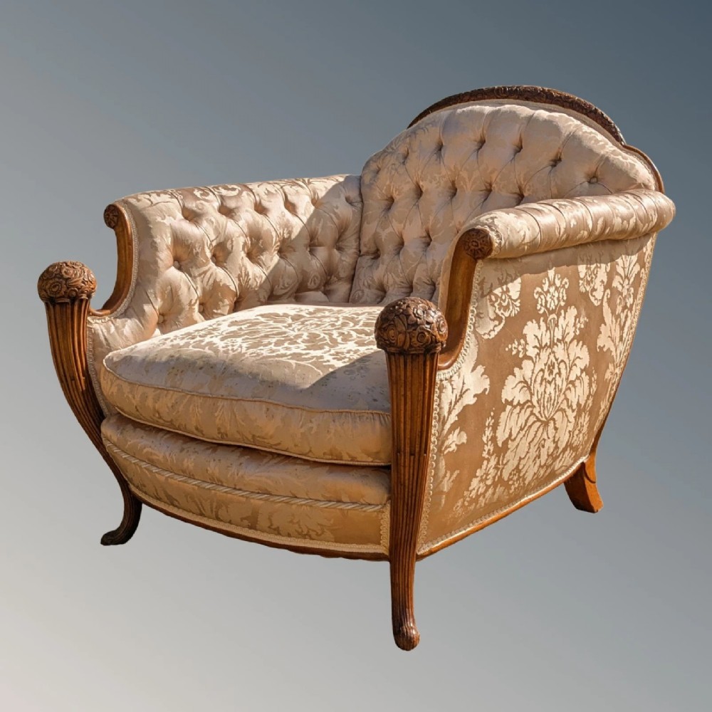 A pair of French armchairs with carved walnut frames and deep-buttoned champagne silk upholstery. View III