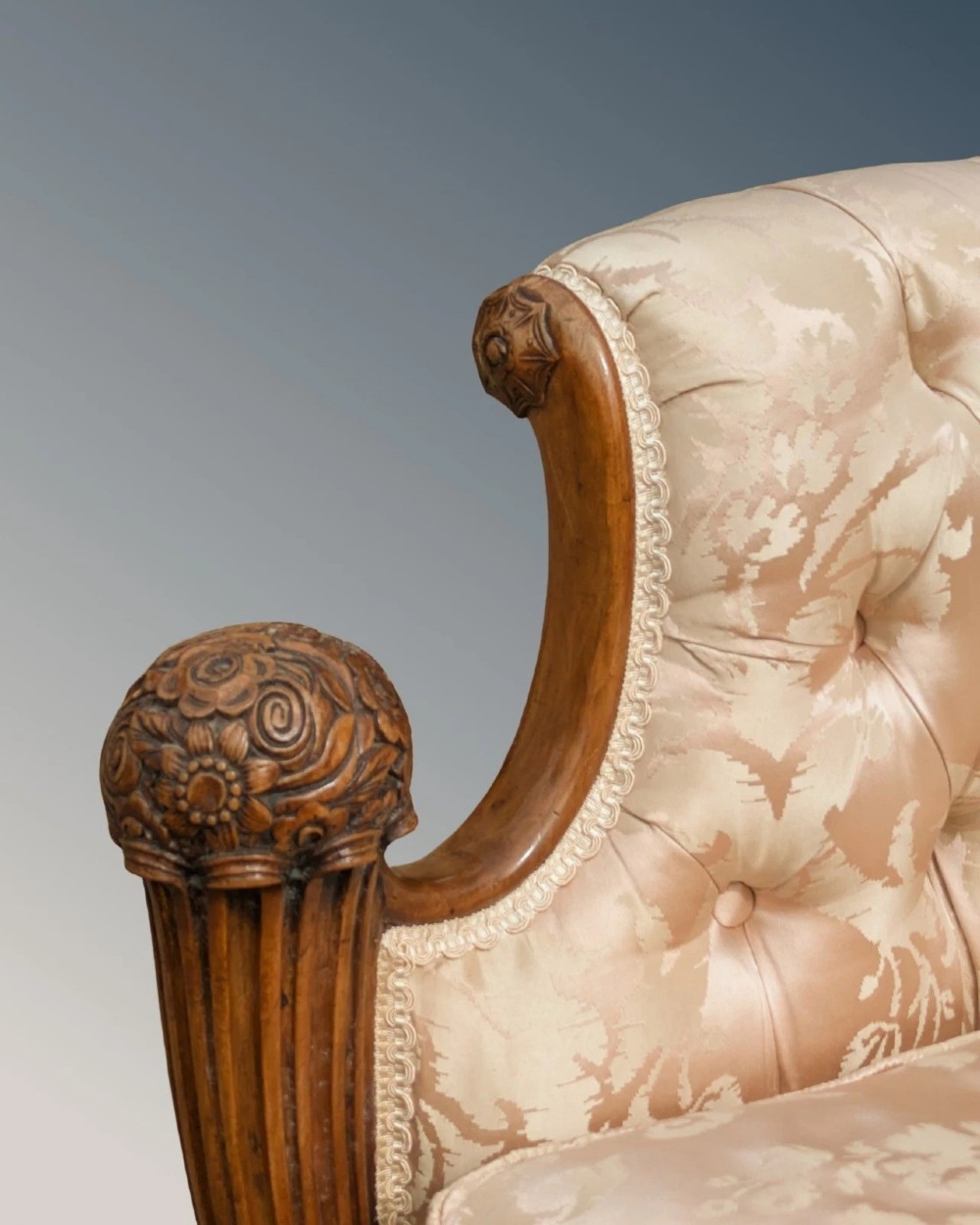 A pair of French armchairs with carved walnut frames and deep-buttoned champagne silk upholstery. View V