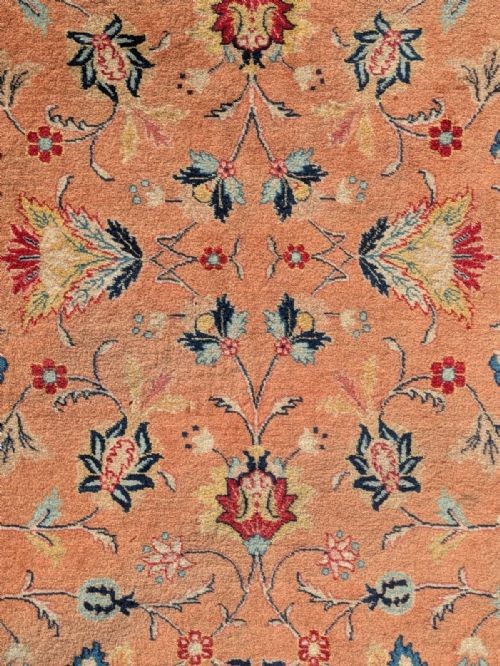An antique hand-knotted Tabriz carpet featuring a terracotta central field decorated with intricate floral motifs and framed by layered ivory and navy decorative borders. View III