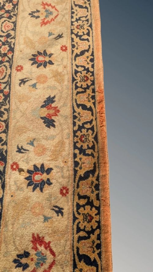An antique hand-knotted Tabriz carpet featuring a terracotta central field decorated with intricate floral motifs and framed by layered ivory and navy decorative borders. View IX