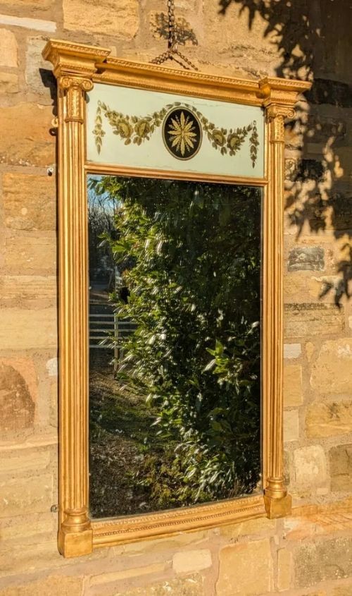 A tall rectangular Regency giltwood pier mirror featuring fluted side columns, an architectural pediment, and an upper verre eglomise panel with gilded swags. View III
