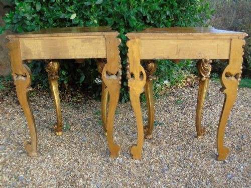 A pair of ornate Spanish giltwood console tables featuring deeply carved shell aprons and cabriole legs resting on scroll feet. View VI