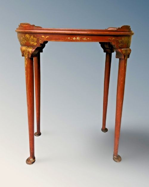 An oval antique red lacquer side table featuring hand-painted gold chinoiserie narrative scenes on the surface and slender legs. View II