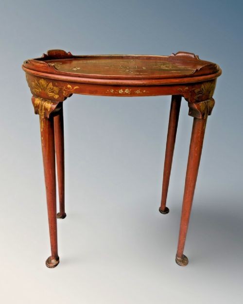 An oval antique red lacquer side table featuring hand-painted gold chinoiserie narrative scenes on the surface and slender legs. View VIII