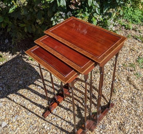 A set of three graduated Regency mahogany nesting tables featuring slender turned legs, curved stretchers, and sledge feet. View II