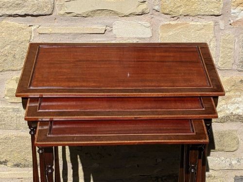 A set of three graduated Regency mahogany nesting tables featuring slender turned legs, curved stretchers, and sledge feet. View III