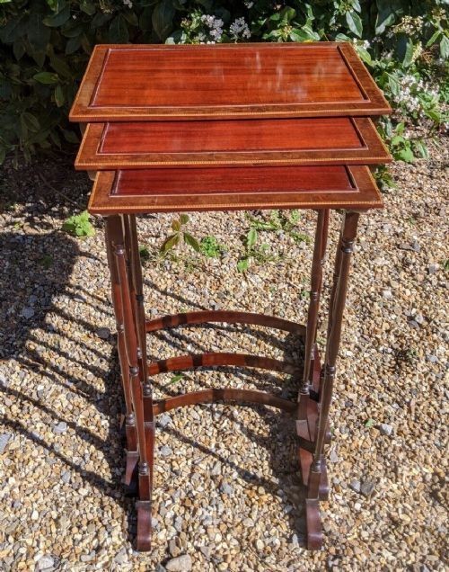 A set of three graduated Regency mahogany nesting tables featuring slender turned legs, curved stretchers, and sledge feet. View V