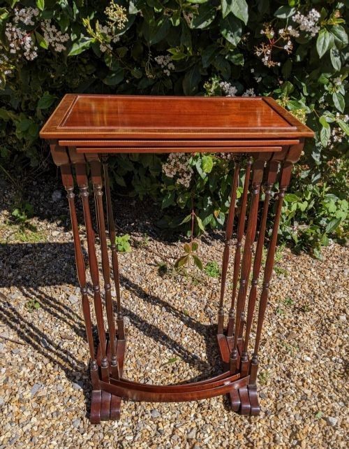 A set of three graduated Regency mahogany nesting tables featuring slender turned legs, curved stretchers, and sledge feet. View VI