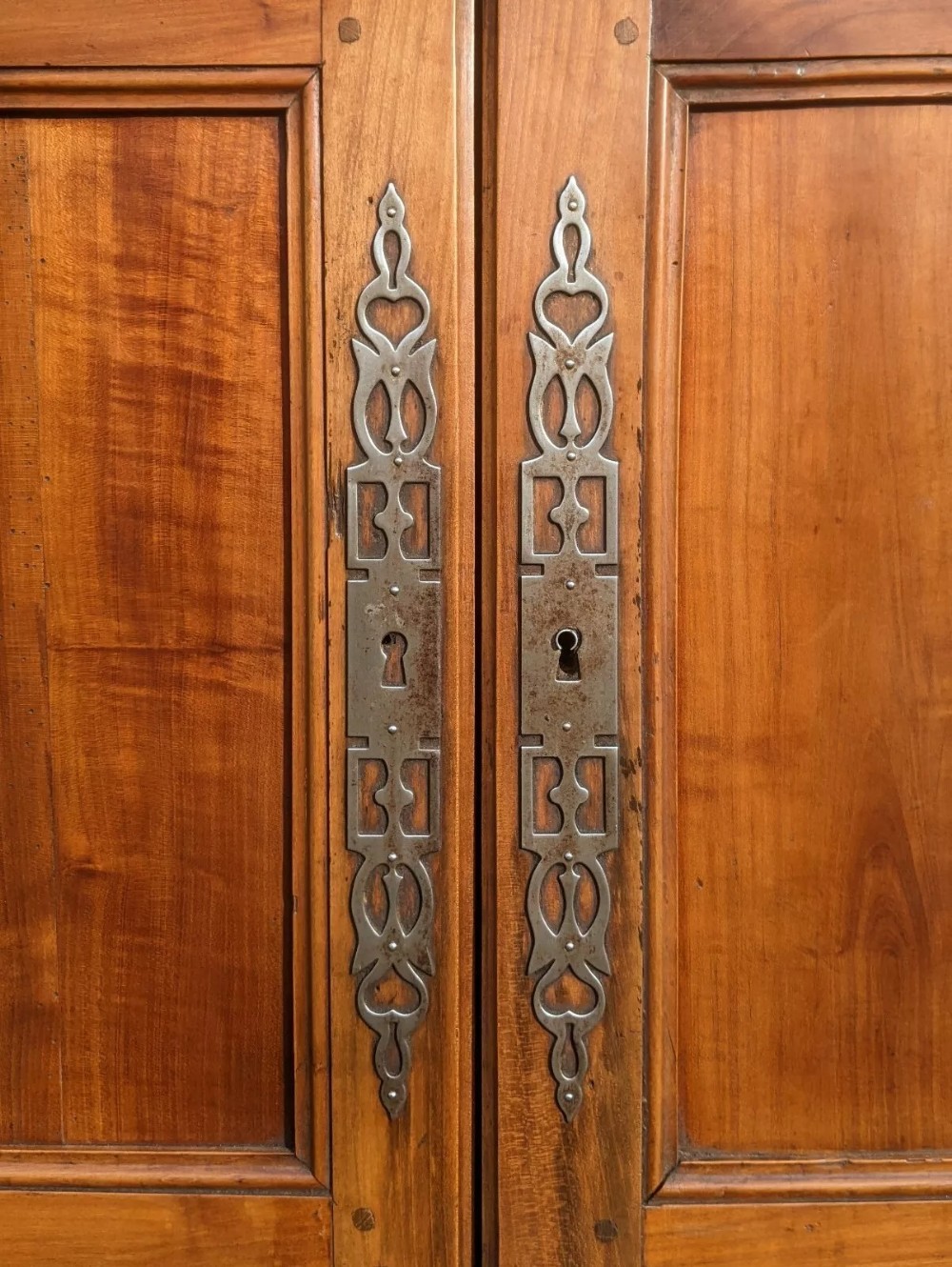 A French provincial fruitwood pantry cabinet featuring upper spindle-front doors, two central drawers with steel handles, lower solid panel doors, and carved cabriole feet. View VI