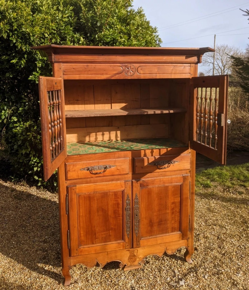 A French provincial fruitwood pantry cabinet featuring upper spindle-front doors, two central drawers with steel handles, lower solid panel doors, and carved cabriole feet. View VII