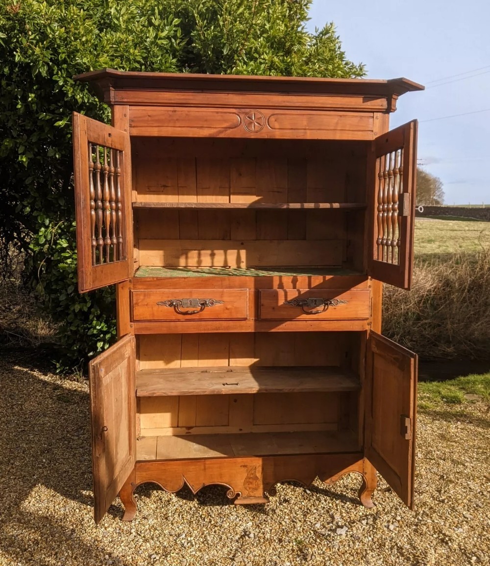 A French provincial fruitwood pantry cabinet featuring upper spindle-front doors, two central drawers with steel handles, lower solid panel doors, and carved cabriole feet. View VIII