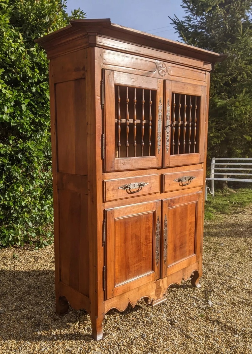 A French provincial fruitwood pantry cabinet featuring upper spindle-front doors, two central drawers with steel handles, lower solid panel doors, and carved cabriole feet. View X