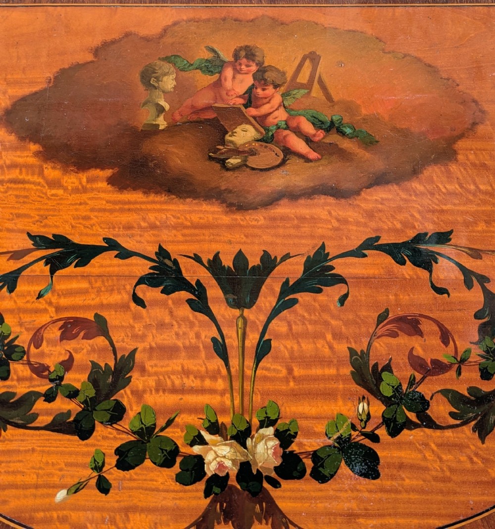 A Regency satinwood demilune side table featuring hand-painted floral garlands and slender tapered legs. View IV