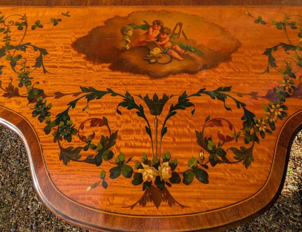 A Regency satinwood demilune side table featuring hand-painted floral garlands and slender tapered legs. View IX