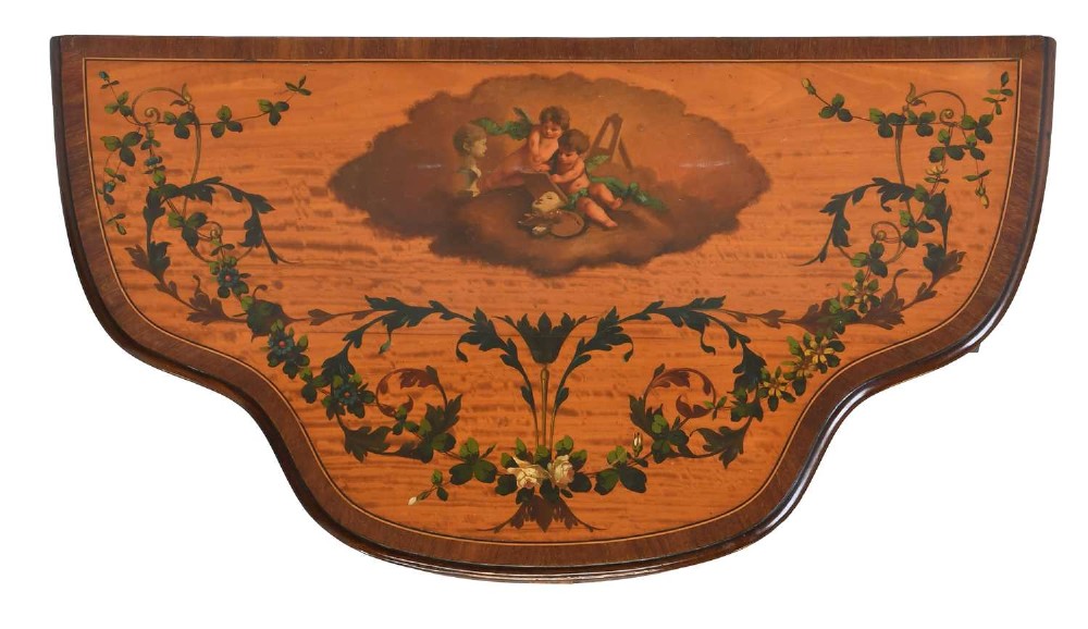 A Regency satinwood side table with a shaped top decorated with hand-painted floral swags and a central cherub medallion, supported by slim tapering legs. View IV