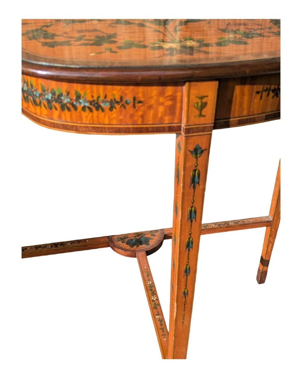 A Regency satinwood side table with a shaped top decorated with hand-painted floral swags and a central cherub medallion, supported by slim tapering legs. View XI