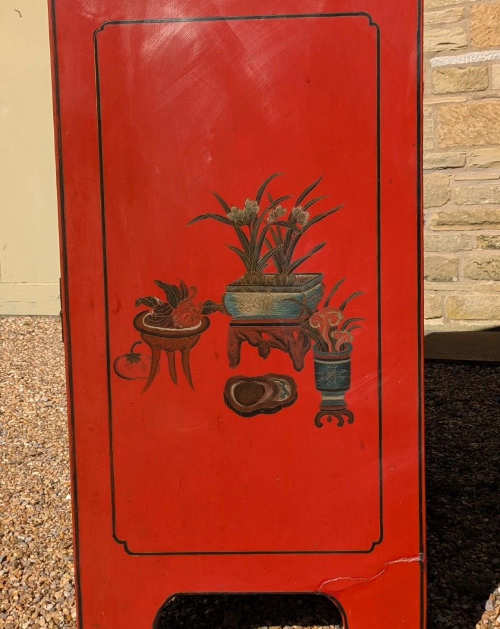 A red lacquered two-door Chinese cabinet decorated with black and gold hand-painted floral and bird motifs, supported on straight block feet and fitted with brass hardware. View IX