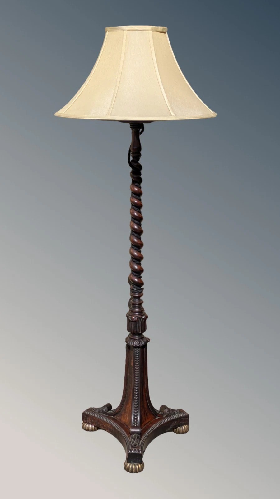 A dark rosewood Regency standard lamp featuring a barley twist column, a carved triform base with brass feet, and a cream fabric shade. View III