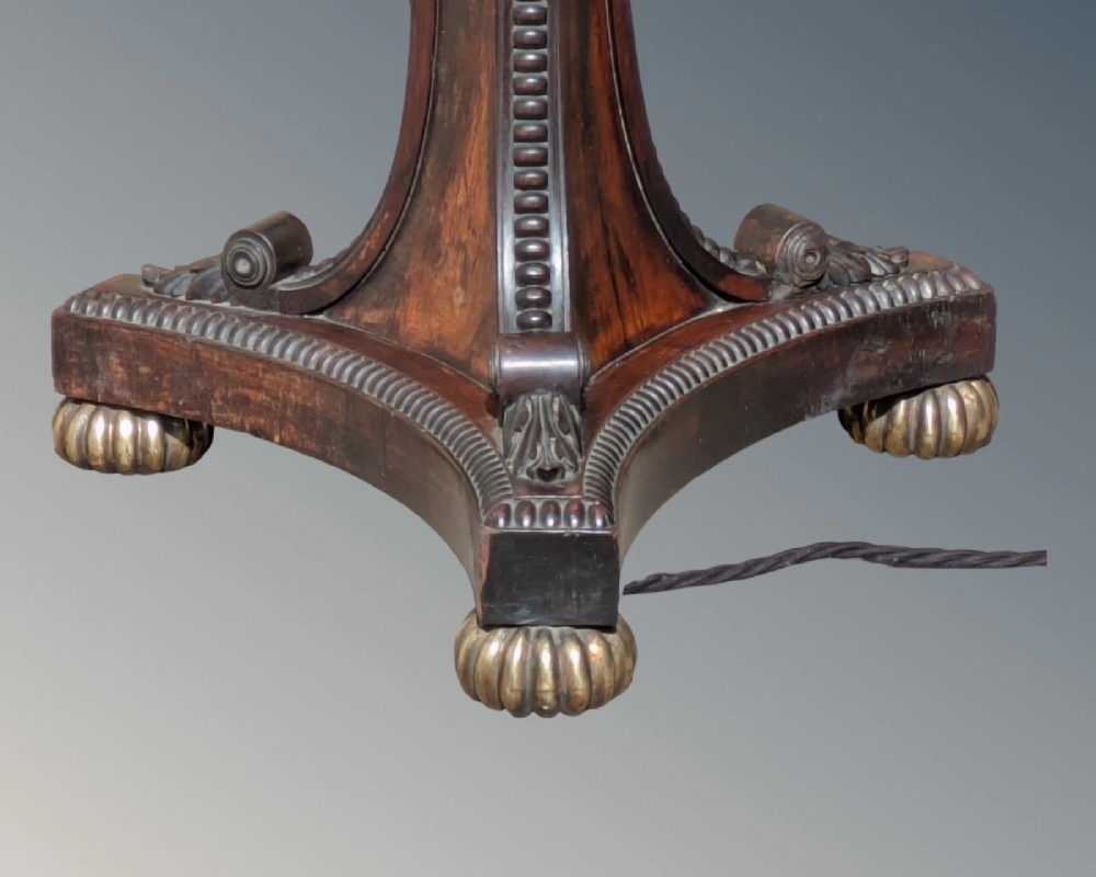 A dark rosewood Regency standard lamp featuring a barley twist column, a carved triform base with brass feet, and a cream fabric shade. View IV