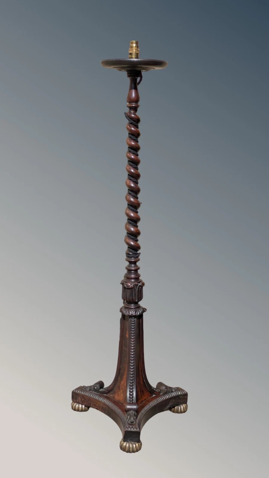 A dark rosewood Regency standard lamp featuring a barley twist column, a carved triform base with brass feet, and a cream fabric shade. View VI