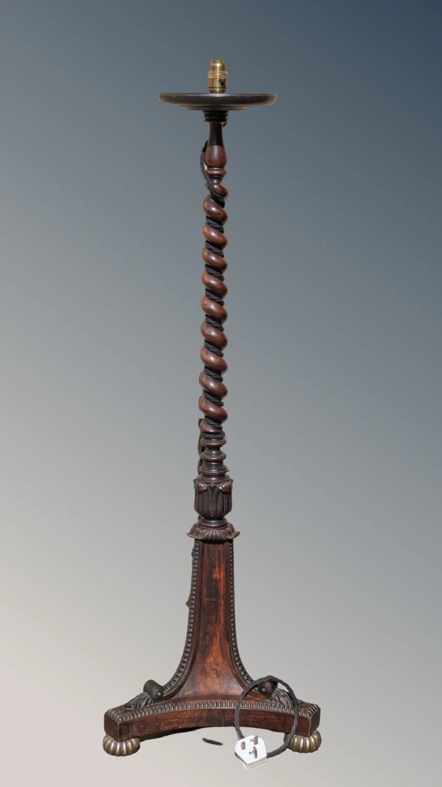 A dark rosewood Regency standard lamp featuring a barley twist column, a carved triform base with brass feet, and a cream fabric shade. View VII