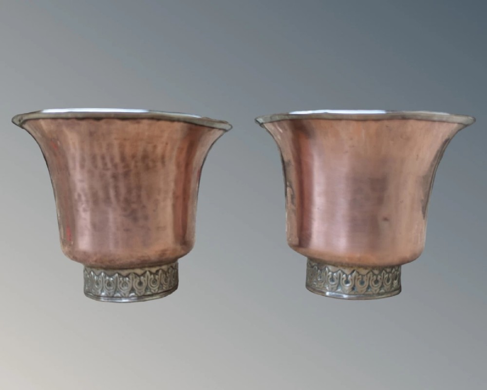 A pair of antique Tibetan flared drinking vessels with hand-hammered copper bodies, silver-lined interiors, and carved silver bases. View III