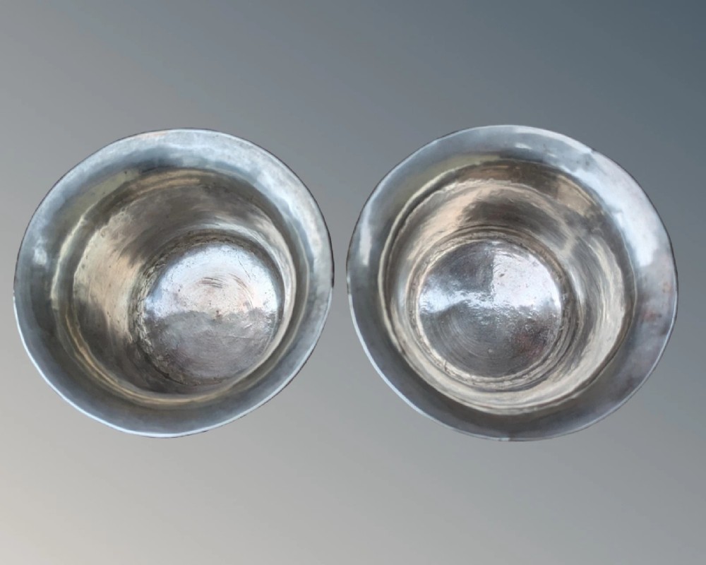 A pair of antique Tibetan flared drinking vessels with hand-hammered copper bodies, silver-lined interiors, and carved silver bases. View VI