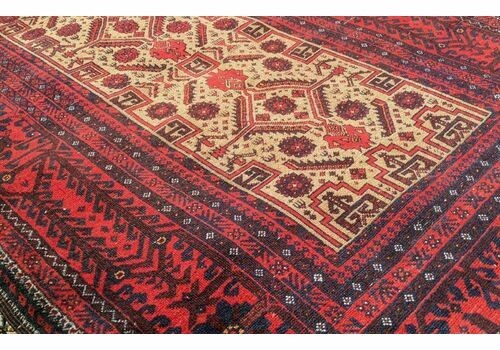 An antique Balouch tribal carpet featuring a cream central field with geometric diamond motifs surrounded by a deep red and navy blue geometric border. View IV